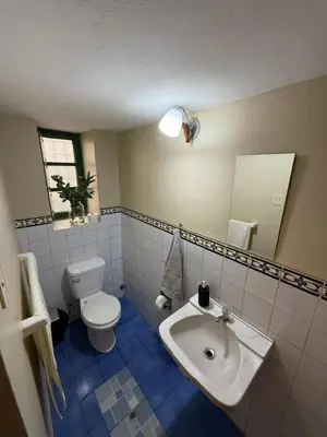 a bathroom with a white toilet and a sink at Acogedor Departamento en Barrio Resbalosa, a 5 Min de la Plaza de Cusco in Cusco