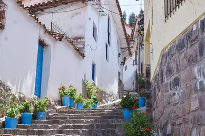 an alley with blue potted plants on the stairs at Acogedor Departamento en Barrio Resbalosa, a 5 Min de la Plaza de Cusco in Cusco
