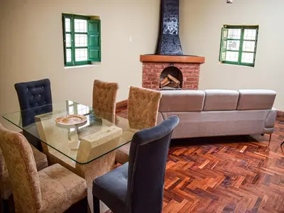 a dining room with a glass table and a fireplace at Acogedor Departamento en Barrio Resbalosa, a 5 Min de la Plaza de Cusco in Cusco