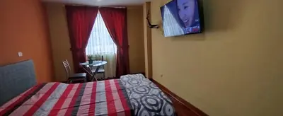 a bedroom with a bed and a tv on the wall at Habitación H3, TV y WIFI cerca a Barranco in Lima