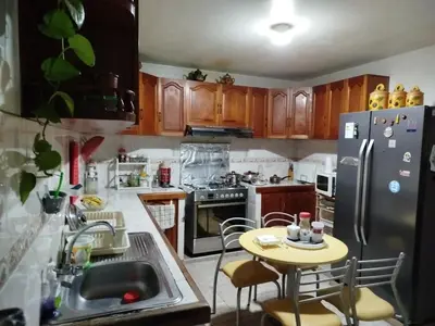 a kitchen with a table and a refrigerator at Habitación H3, TV y WIFI cerca a Barranco in Lima