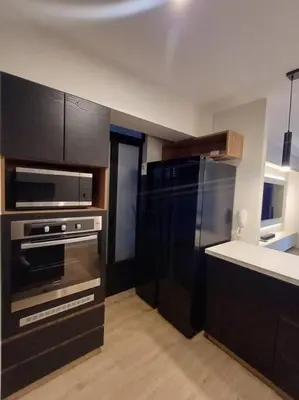 a kitchen with black cabinets and a stainless steel appliance at Luxurious Apartment Besso in Lima