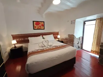 a bedroom with a large bed with a wedding decoration on it at Afma Cusco in Cusco