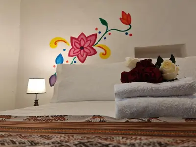 a bedroom with a bed with flowers on the wall at Afma Cusco in Cusco