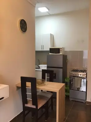 a kitchen with a table and chairs and a stove at Suite 201 in Lima