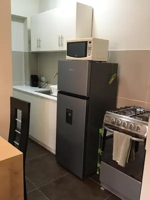 a kitchen with a microwave on top of a refrigerator at Suite 201 in Lima