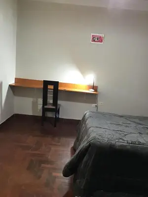 a bedroom with a bed and a desk and a chair at Suite 201 in Lima