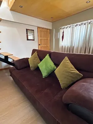 a brown couch with pillows on it in a living room at Duplex panorámico in Cusco