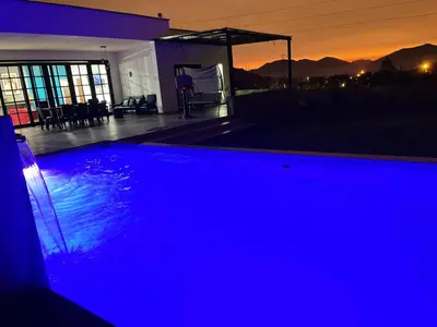 a swimming pool lit up in blue at night at Cieneguilla Dreams in Cieneguilla