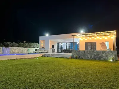 a house lit up at night with a lawn in front at Cieneguilla Dreams in Cieneguilla