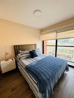 a bedroom with a bed and a large window at MONTERRICO POLO APARTS #20 - DEPARTAMENTO DELUXe FRENTE EMBAJADA USA in Lima