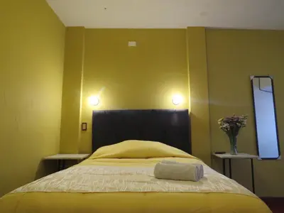 a bedroom with a bed with two lights on the wall at La Casa de Abril Cusco in Cusco