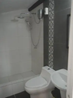 a bathroom with a toilet and a shower and a sink at Blue Shark Apartments in San Bartolo