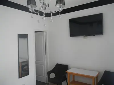 a living room with a tv and a table and chairs at Blue Shark Apartments in San Bartolo