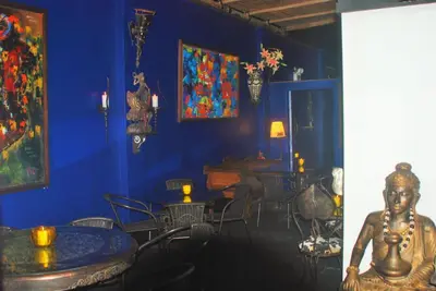 a blue room with a table and a statue in it at Blue Shark Apartments in San Bartolo