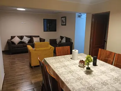 a living room with a table and a couch at La Casa de Anni Departamento 3 in Oxapampa
