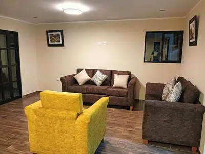 a living room with two chairs and a couch at La Casa de Anni Departamento 3 in Oxapampa