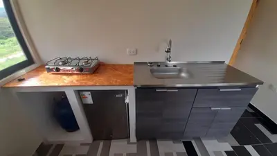 a small kitchen with a sink and a stove at La Casa de Anni Departamento 2 in Oxapampa