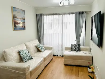 a living room with a white couch and a chair at Alojamiento Mama Ocllo in Lima