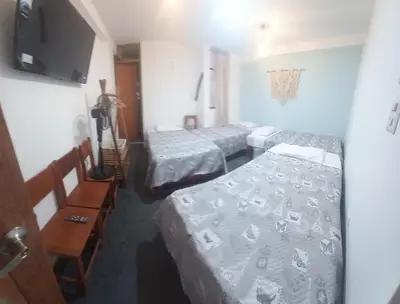 a room with three beds and a flat screen tv at Hospedaje velilu in Ica