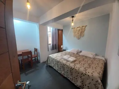 a small bedroom with a bed and a table at Hospedaje velilu in Ica