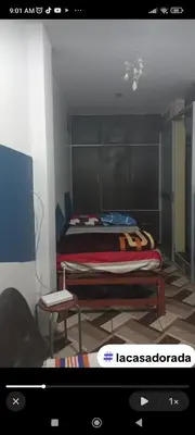 a bedroom with a bed and a table and a chair at La casa dorada in Huacho