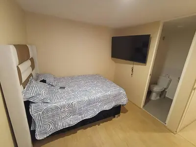 a small room with a bed and a flat screen tv at Departamento en estreno Alameda Central in Lima
