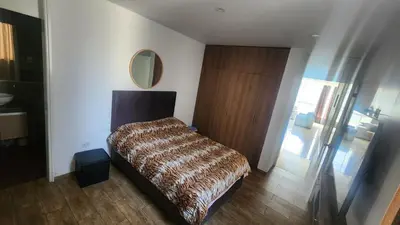 a bedroom with a bed and a mirror on the wall at Departamento exclusivo ica in Ica