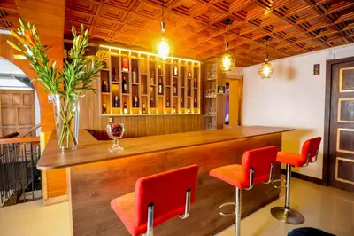 a bar with red chairs and a vase of flowers at San Francisco Pardo Hotel in Cusco
