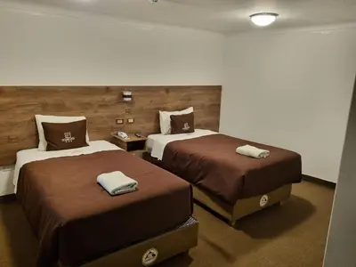 a hotel room with two beds with towels on them at San Francisco Pardo Hotel in Cusco