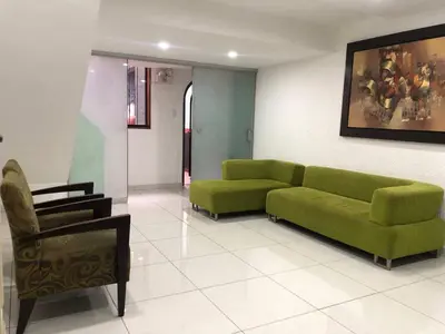 a living room with a green couch and a chair at Departamento en corazón de Miraflores in Lima