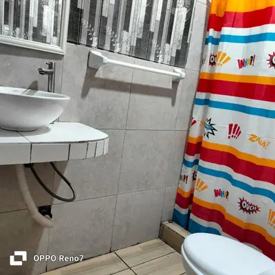 a bathroom with a sink and a shower curtain at Casita de camucha in Chincha Baja