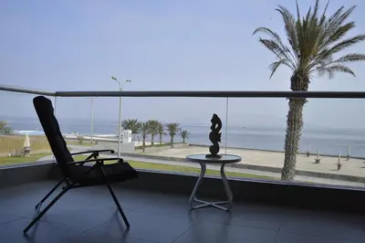 a room with a view of the ocean and a chair at Apartamento Frente a Islas Ballestas in Paracas