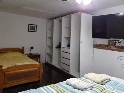 a bedroom with two beds and a flat screen tv at Hospedaje interno surco in Lima