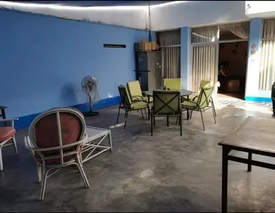 a room with chairs and tables and a blue wall at Hospedaje interno surco in Lima