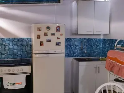 a kitchen with a white refrigerator and a stove at Hospedaje interno surco in Lima