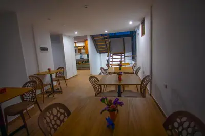 a dining room with tables and chairs and a staircase at MUJU hotel by Ämak in Urubamba