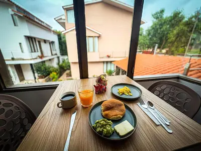 a table with two plates of food and a glass of orange juice at MUJU hotel by Ämak in Urubamba