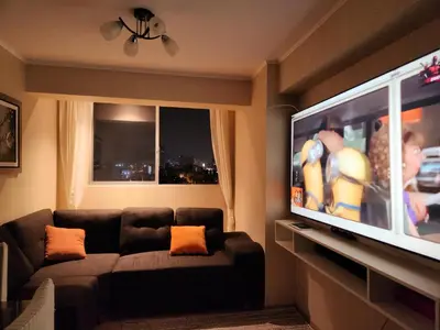 a living room with a couch and a flat screen tv at TOWEr2 in Lima