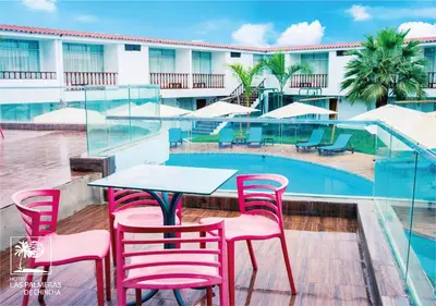 a table and chairs next to a swimming pool at Qallwa Chincha in Chincha Alta