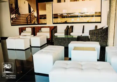 a restaurant with white chairs and a table at Qallwa Chincha in Chincha Alta