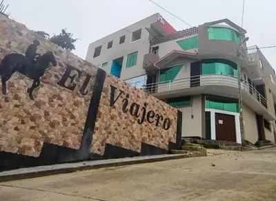 a building with a wall with a sign that reads pizza at Hostal El Viajero in Surcubamba