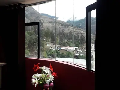 a window with a bunch of flowers in front of it at Hostal El Viajero in Surcubamba