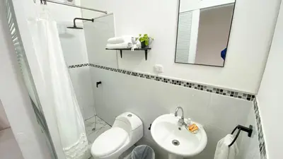 a white bathroom with a sink and a mirror at 2 beds with garden view and terrace in Lima