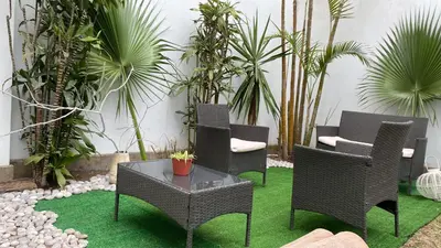 a patio with chairs and a table and plants at 2 beds with garden view and terrace in Lima
