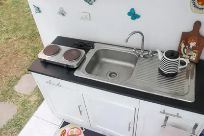 a kitchen counter with a sink and a stove at 2 beds with garden view and terrace in Lima