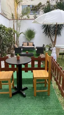 a table and two benches and an umbrella at 2 beds with garden view and terrace in Lima