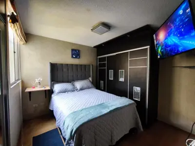 a bedroom with a bed and a flat screen tv at Departamento en Ate in Lima