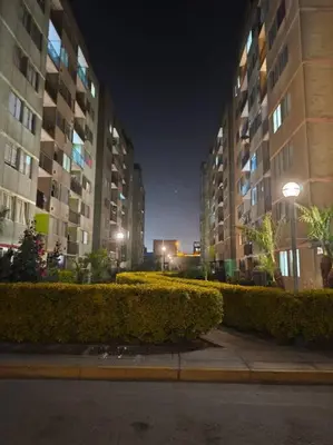 a city street with tall buildings at night at Departamento en Ate in Lima