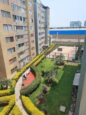 a garden in the middle of a city with buildings at Departamento en Ate in Lima